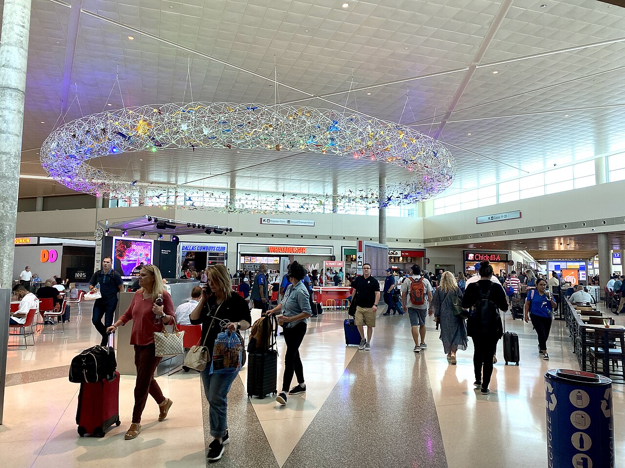 Real main terminal interior at Dallas Love Field with its suspended artwork and travellers